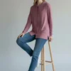 Model sitting on stool wearing Trasaga Transit Air-Cotton hoodie in rose