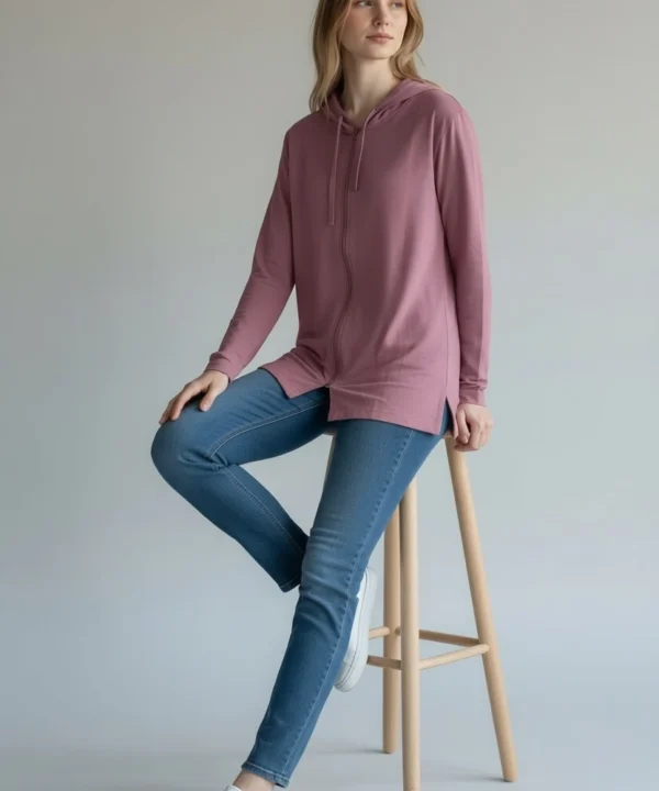Model sitting on stool wearing Trasaga Transit Air-Cotton hoodie in rose
